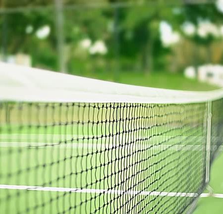 Quelle est la fréquence de maintenance nécessaire pour un court de tennis en gazon synthétique ?
